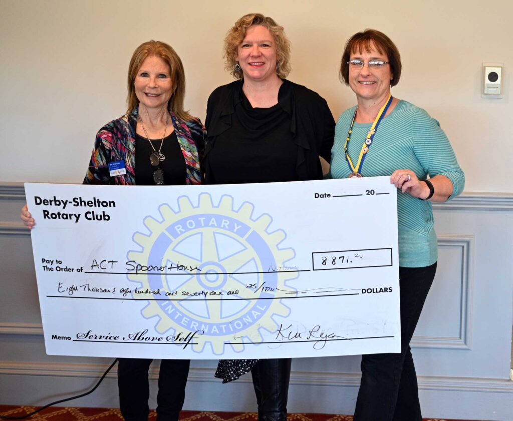 Susan Agamy accepting a check from Kim and Judy.